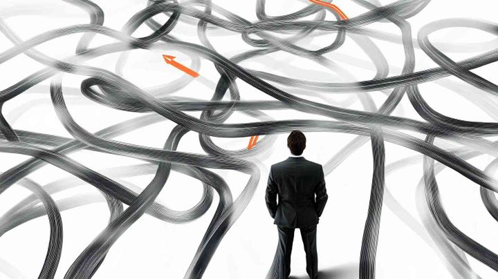 Image of a man in a suit looking at a complex arrangement of strings