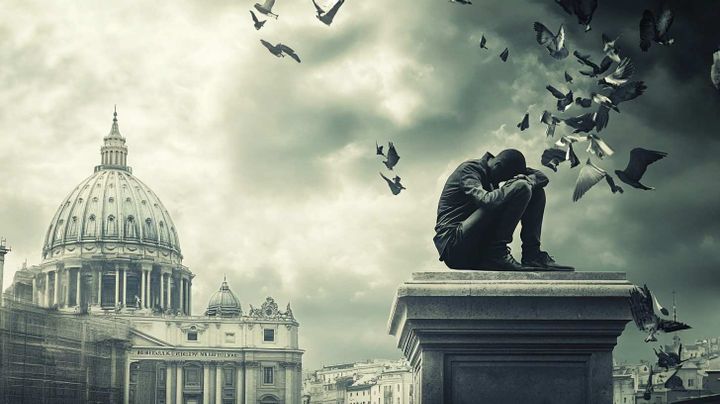 Image of a man sitting in despair close to a domed bank building