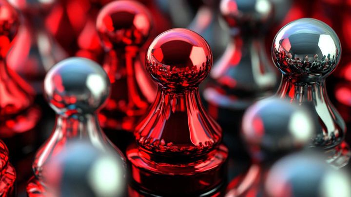 Image of polished metal chess pieces in red and silver