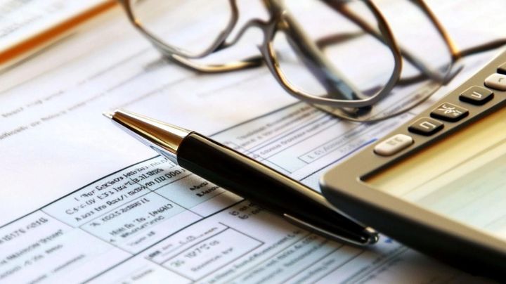 Image of a pen and calculator on a tax form