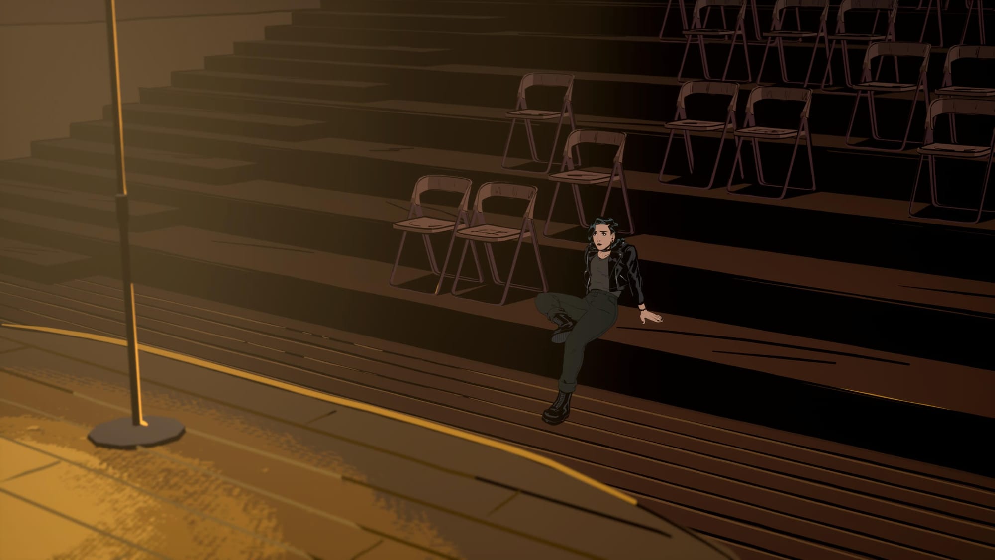 A lone Grace in empty hall in front of the empty stage with a standing microphone
