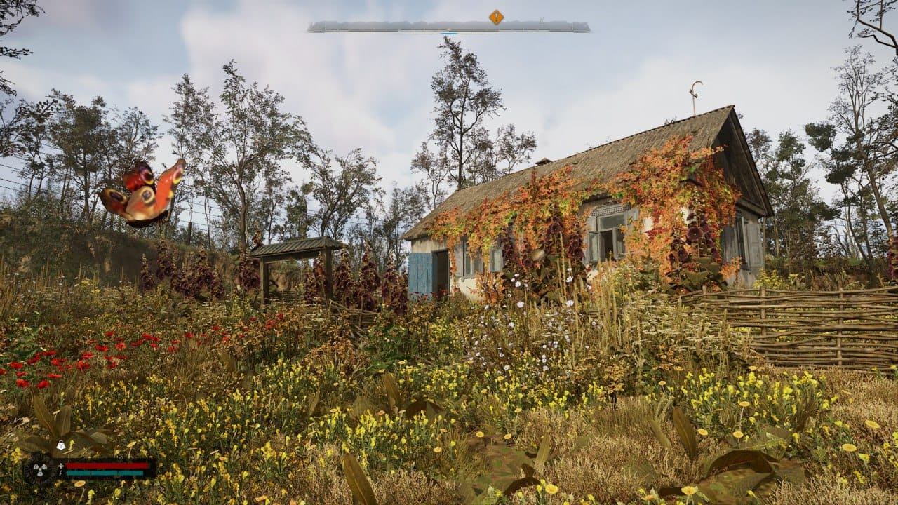 A beatiful old ukrainian village house on a bright day with a lot of vegetation and a butterfly close by