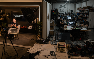 A business creator films in a luxury studio while a busy warehouse operation runs behind the set.