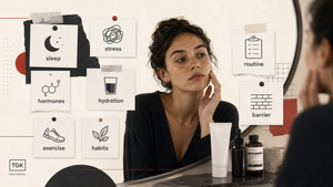 Woman examining her skin in a bathroom mirror beside notes about sleep, stress, hormones, hydration, exercise and skincare habits.