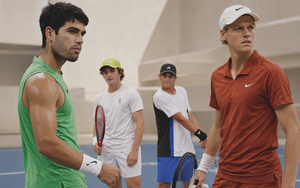 Carlos Alcaraz and Jannik Sinner facing across a tennis court as Rafael Jódar and João Fonseca approach behind them.