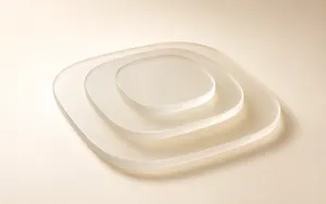 Three translucent frosted-glass rounded panels, decreasing in size and stacked with visible gaps, sit against a warm ivory gradient background with soft studio lighting and subtle shadows.