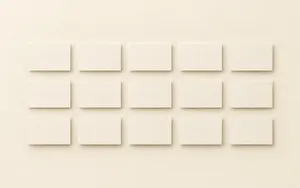 A clean grid of small identical blank rectangular cards, evenly spaced and evenly lit on a seamless warm ivory surface
