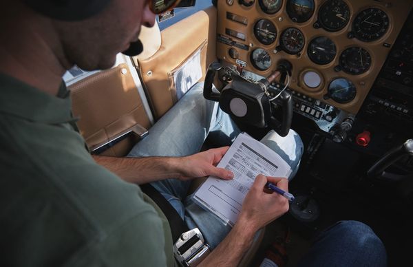 Pilot with a checklist in a cockpit, representing a structured SaaS subscription review before year-end.