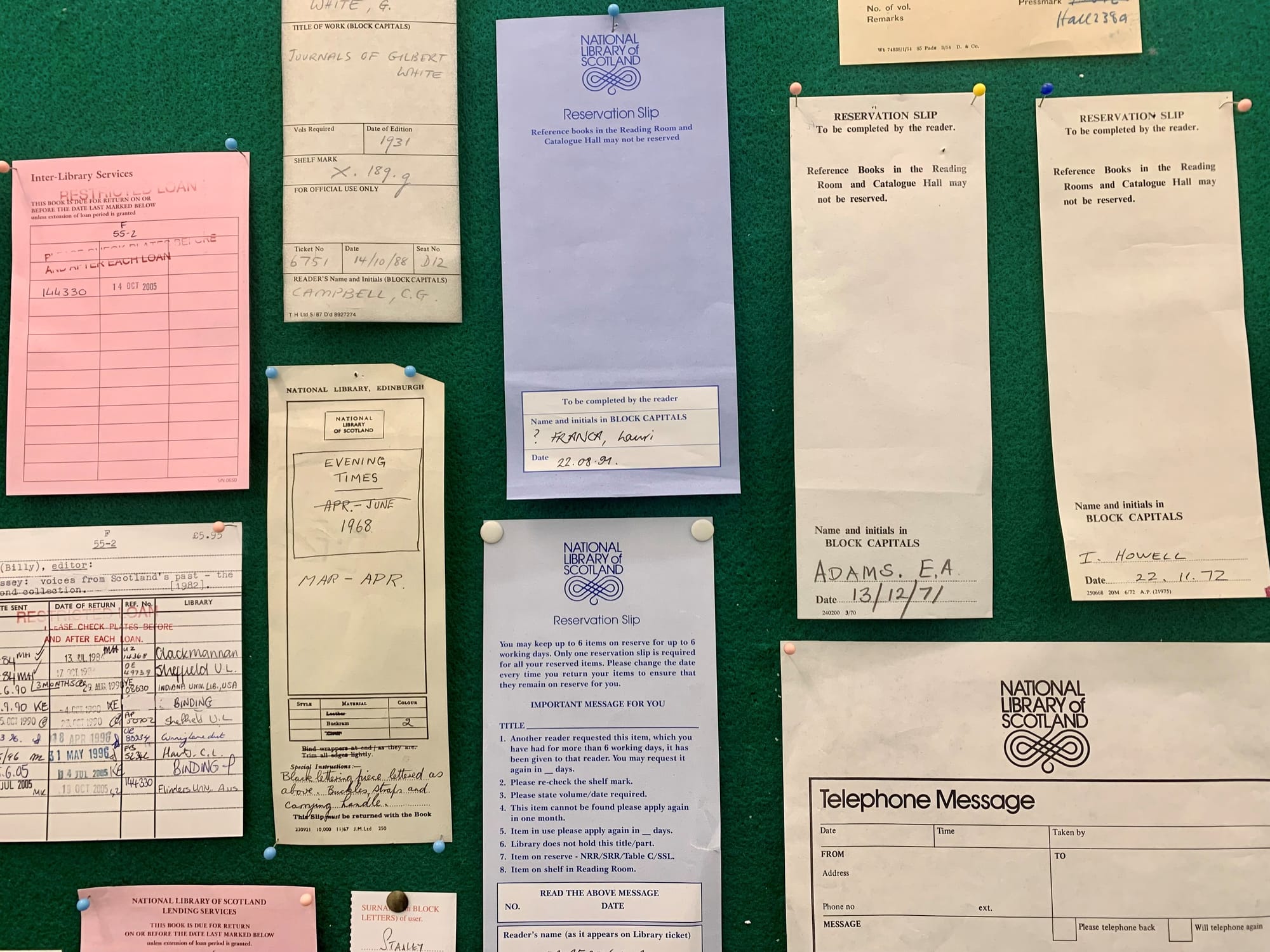 A pinboard of old library reservation slips.