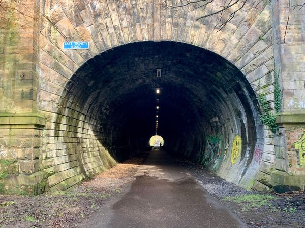 A long stone tunnel on an old railway path.