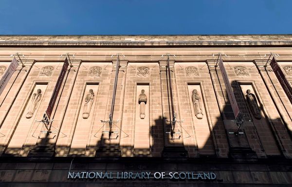 The front of the National Library of Scotland building in sun and shadows, with blue sky above.