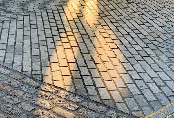 Cobbled street patterns with sunlight pattern. 