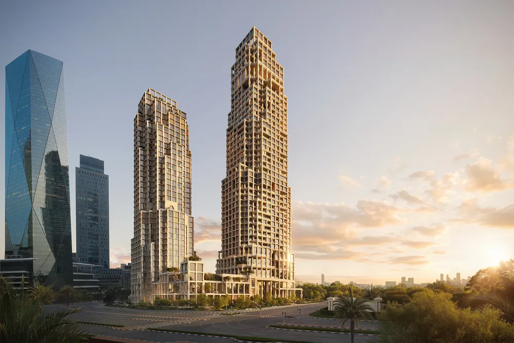 Two gridded beige skyscrapers with terraced greenery rise beside glass towers at sunset