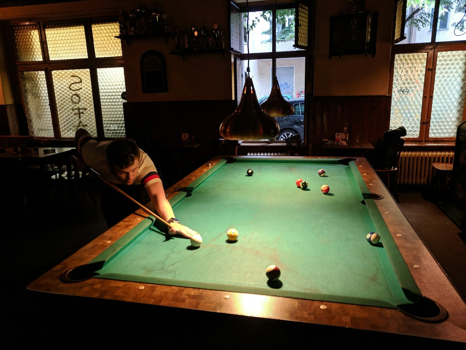 green and brown pool table inside dive bar