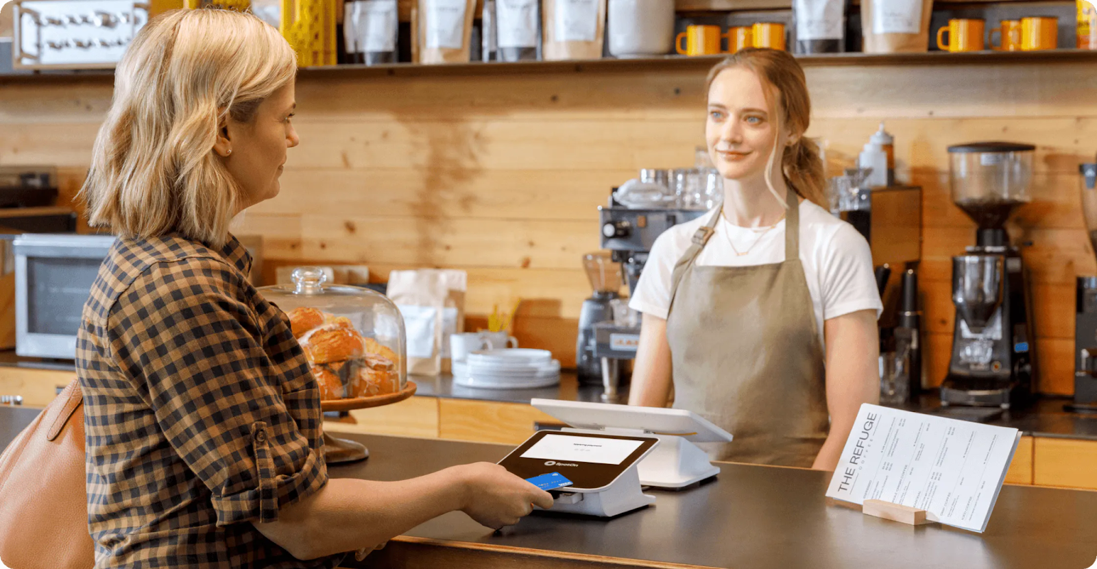 Woman checking out on a SpotOn POS at a cafe.