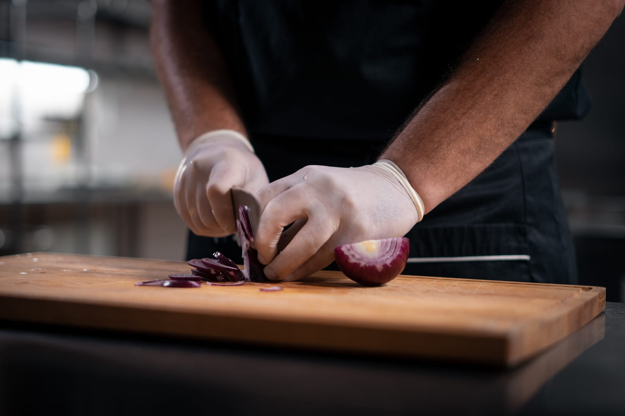 Mexican restaurant chef chopping onions for al pastor burrito meat
