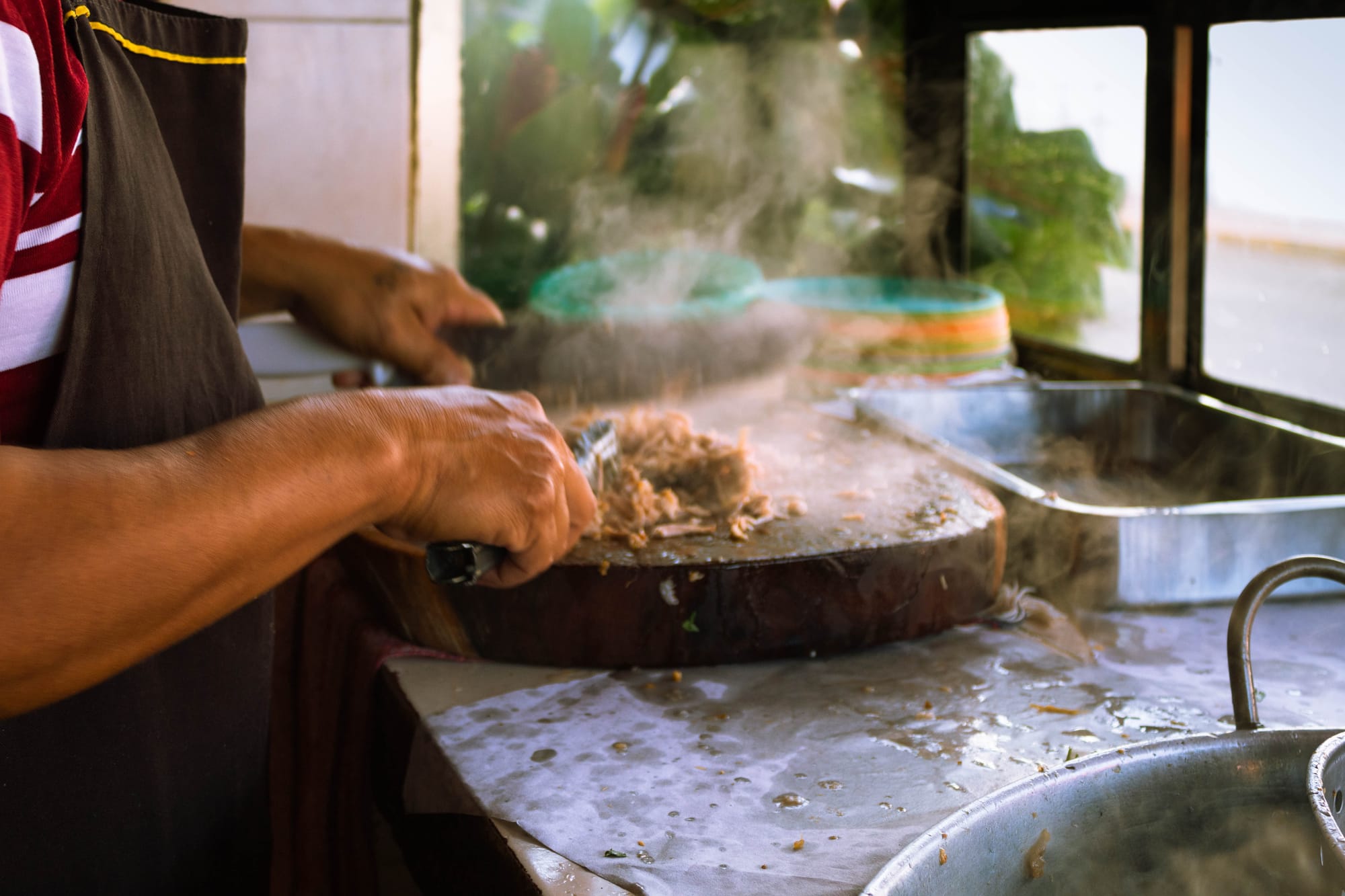 Carnitas grilled in fat next to al pastor meat marinating.