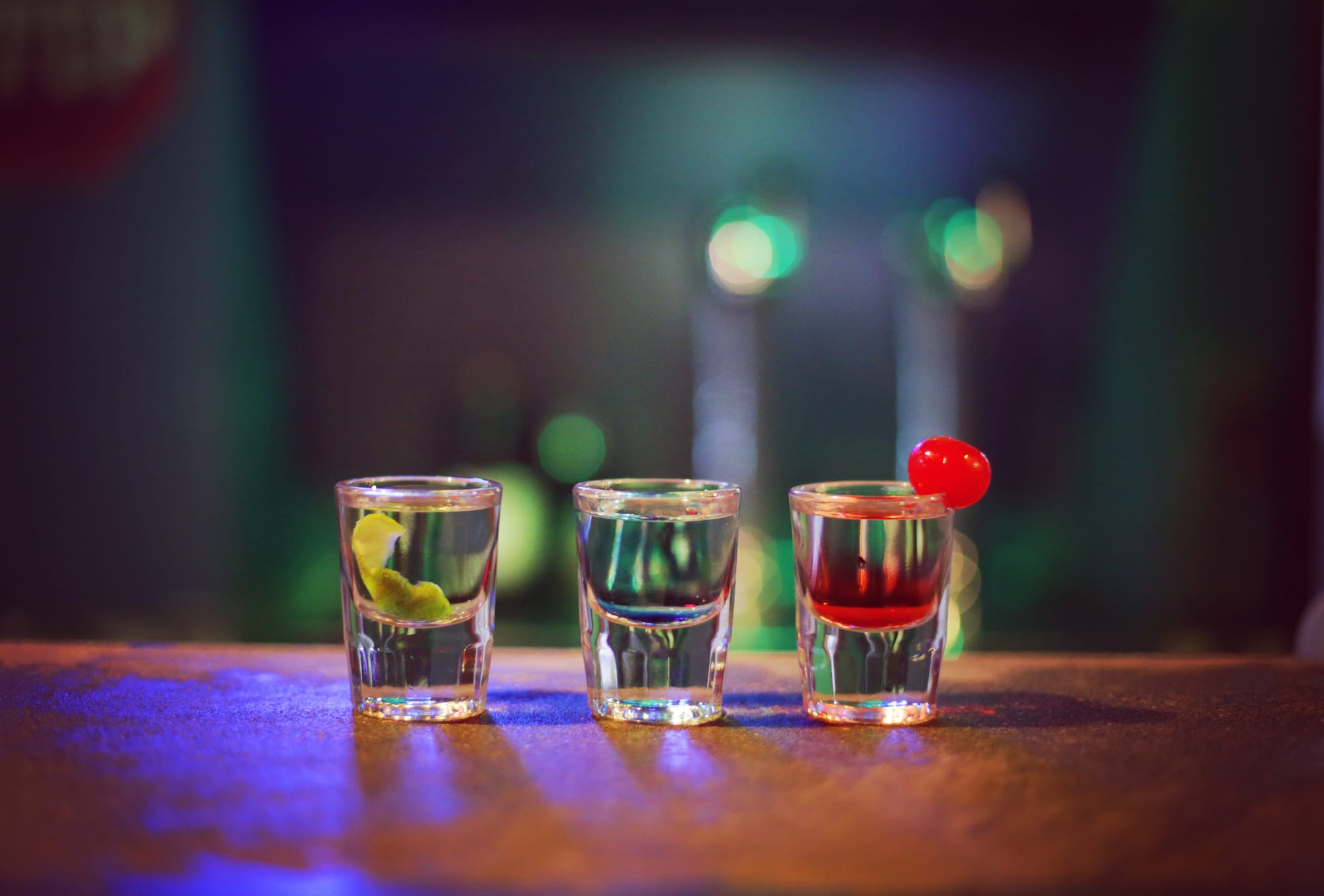 three shot glasses on a bar table countertop