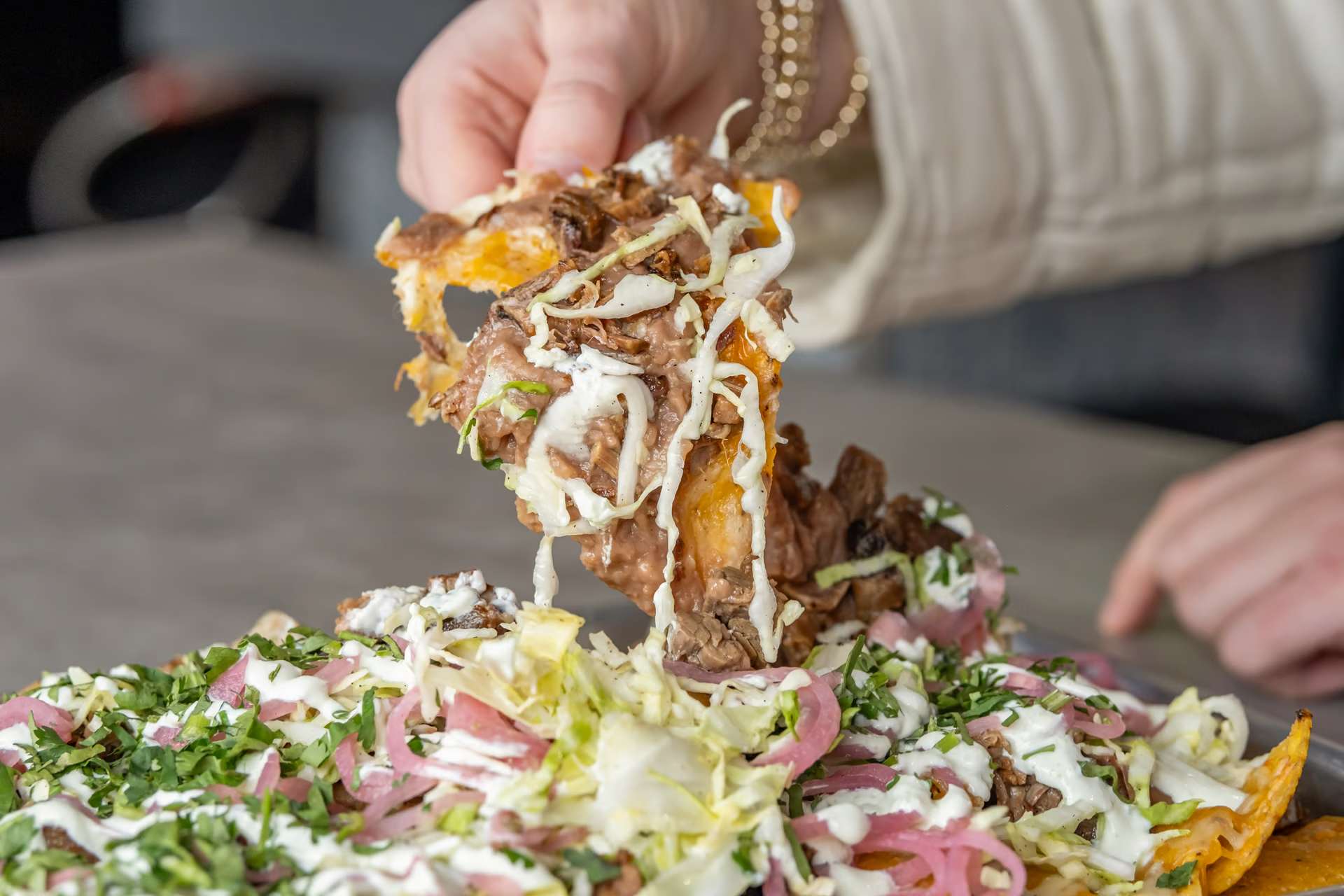A guest eating nachos at Americanos in Chicago