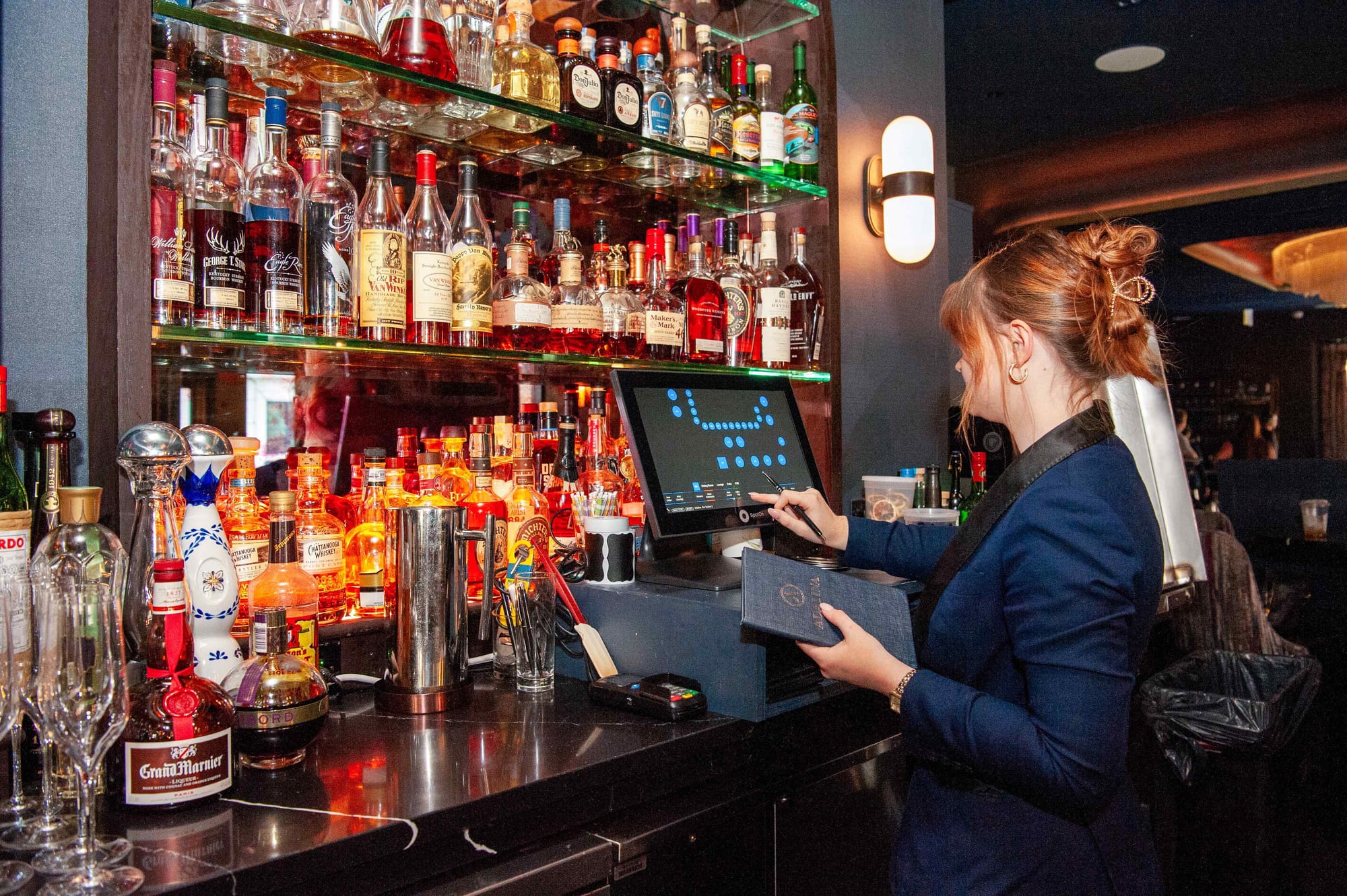 A bartender enters an order into a bar POS