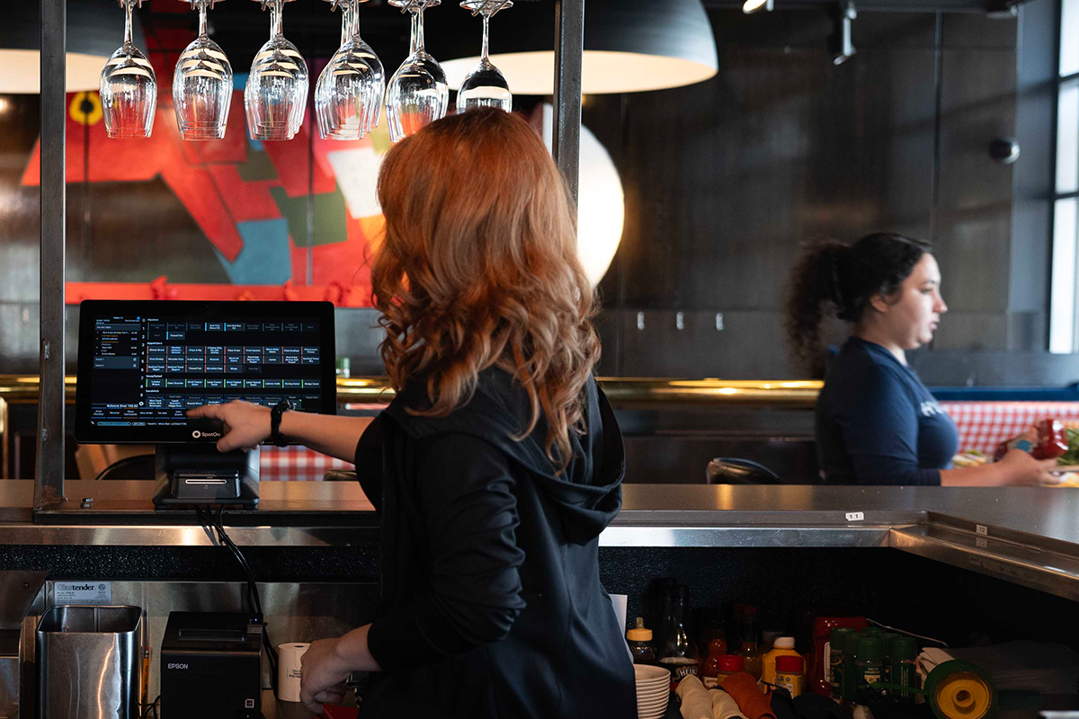 Server using a POS system behind the bar.