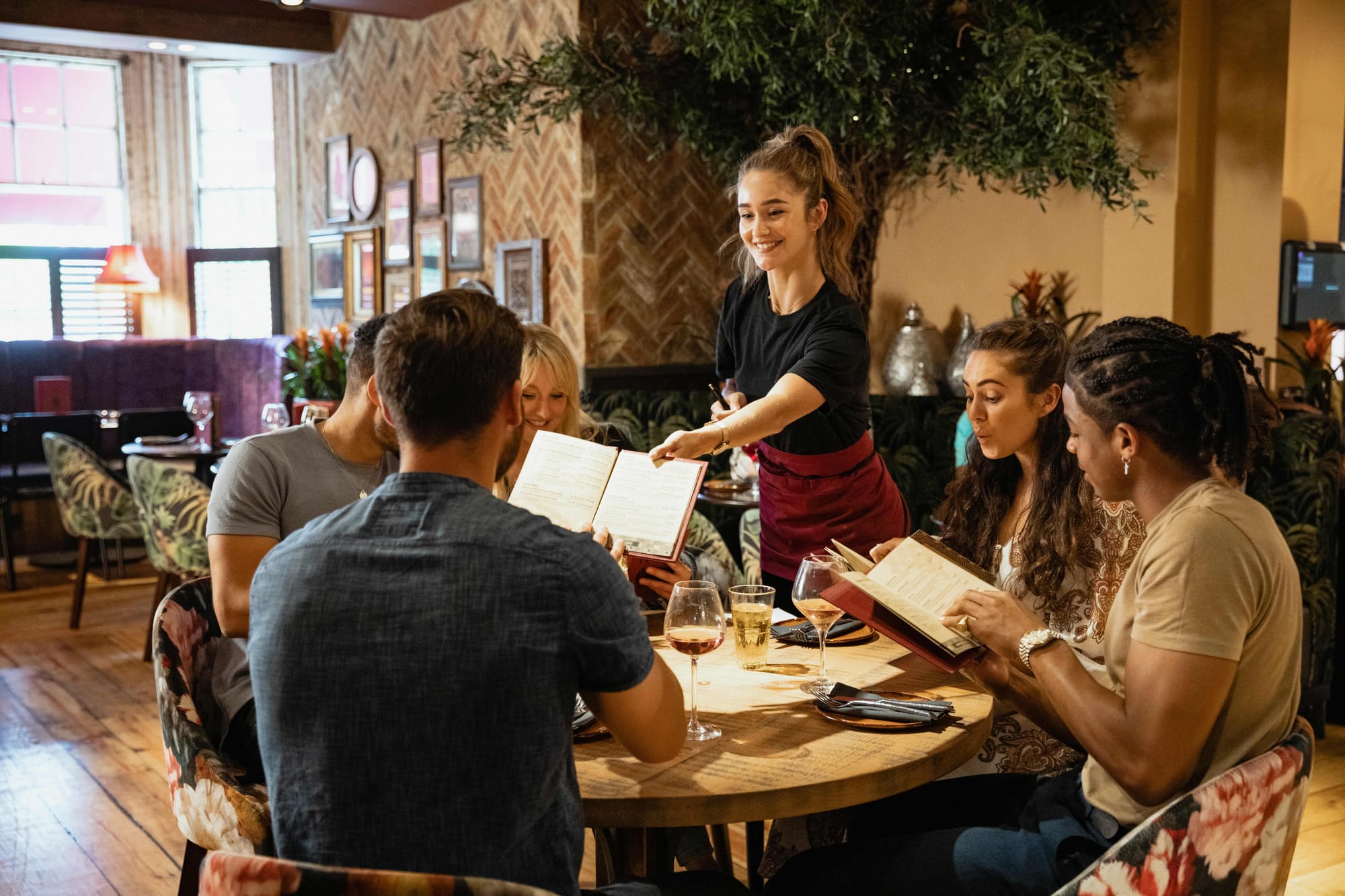 Server giving a menu to a guest at a restaurant