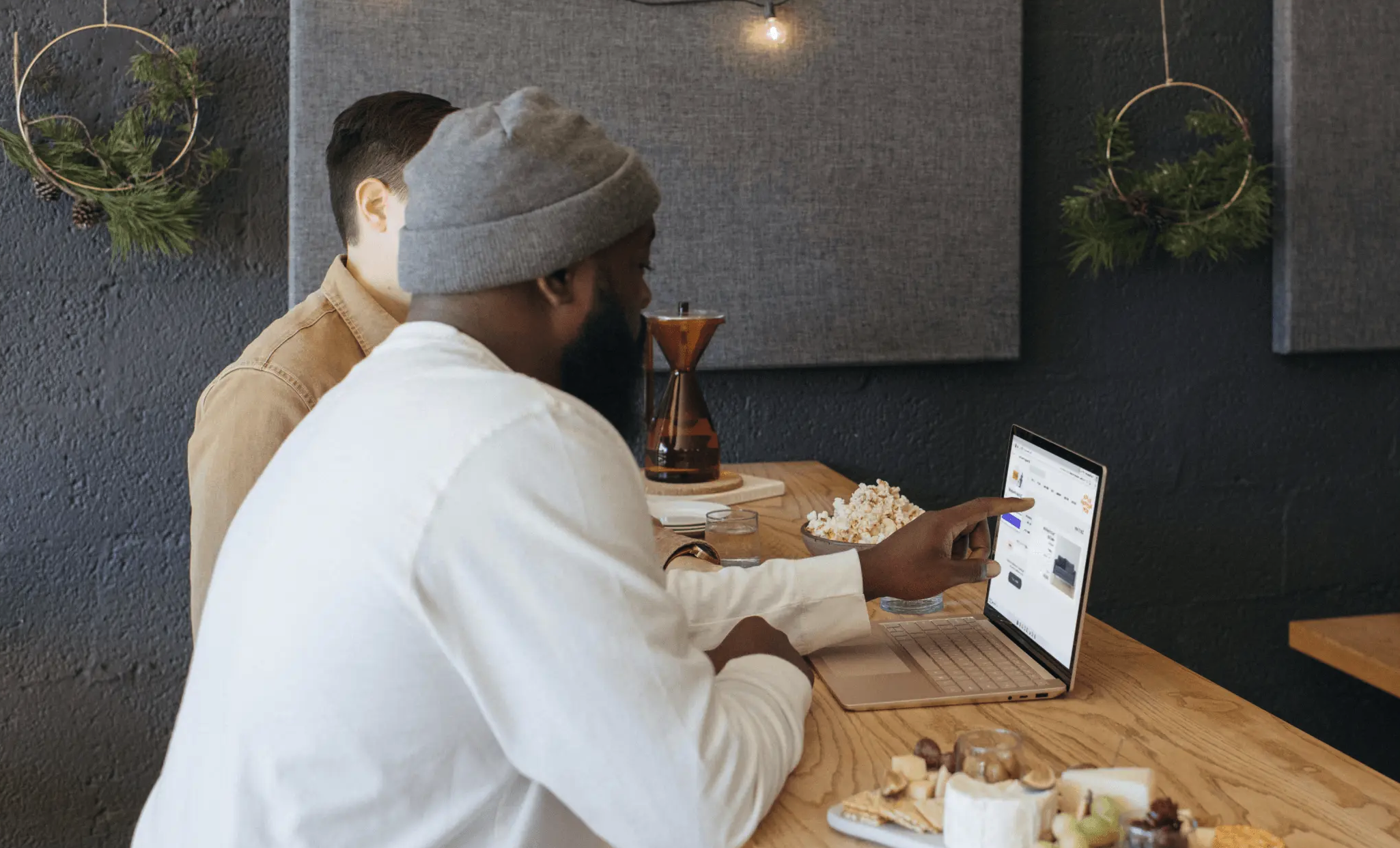 Two restauranteurs review their marketing strategy together on a laptop in their establishment.