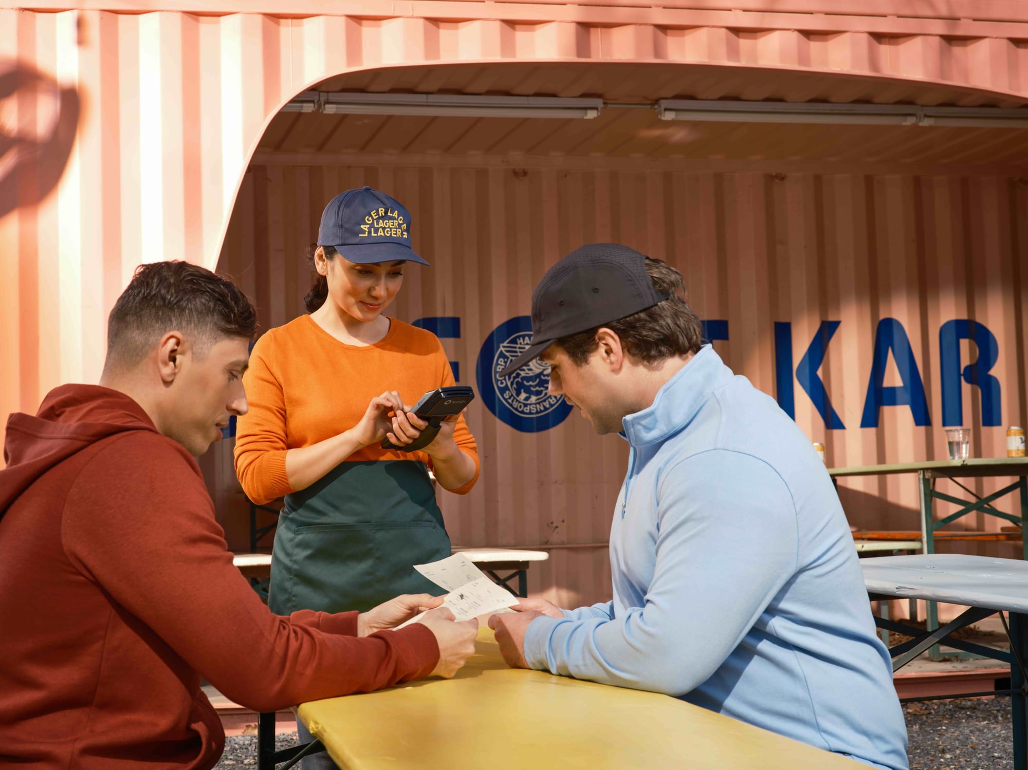 server using handheld POS to take orders on patio