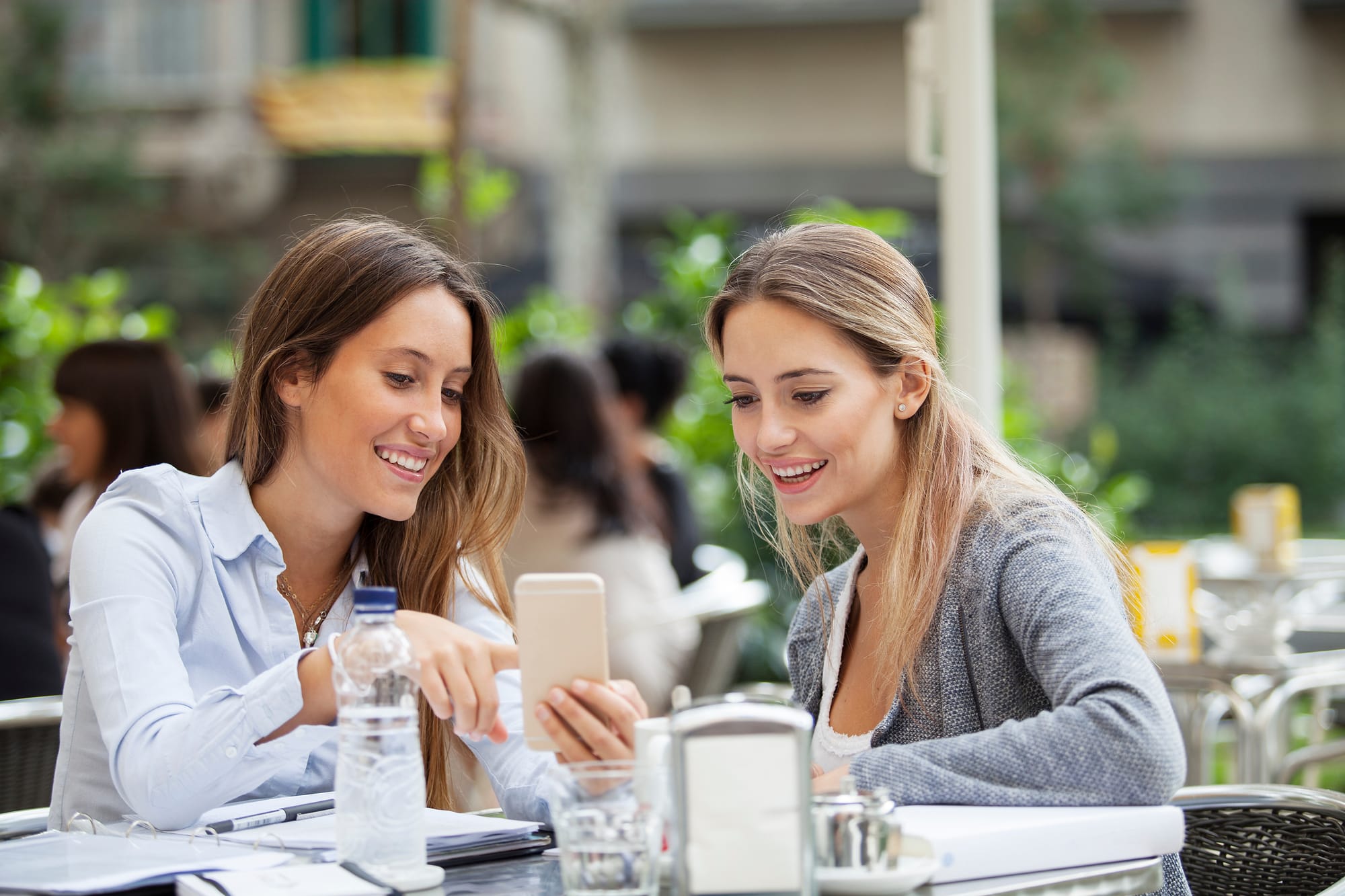 restaurant guests on patio viewing offer on phone