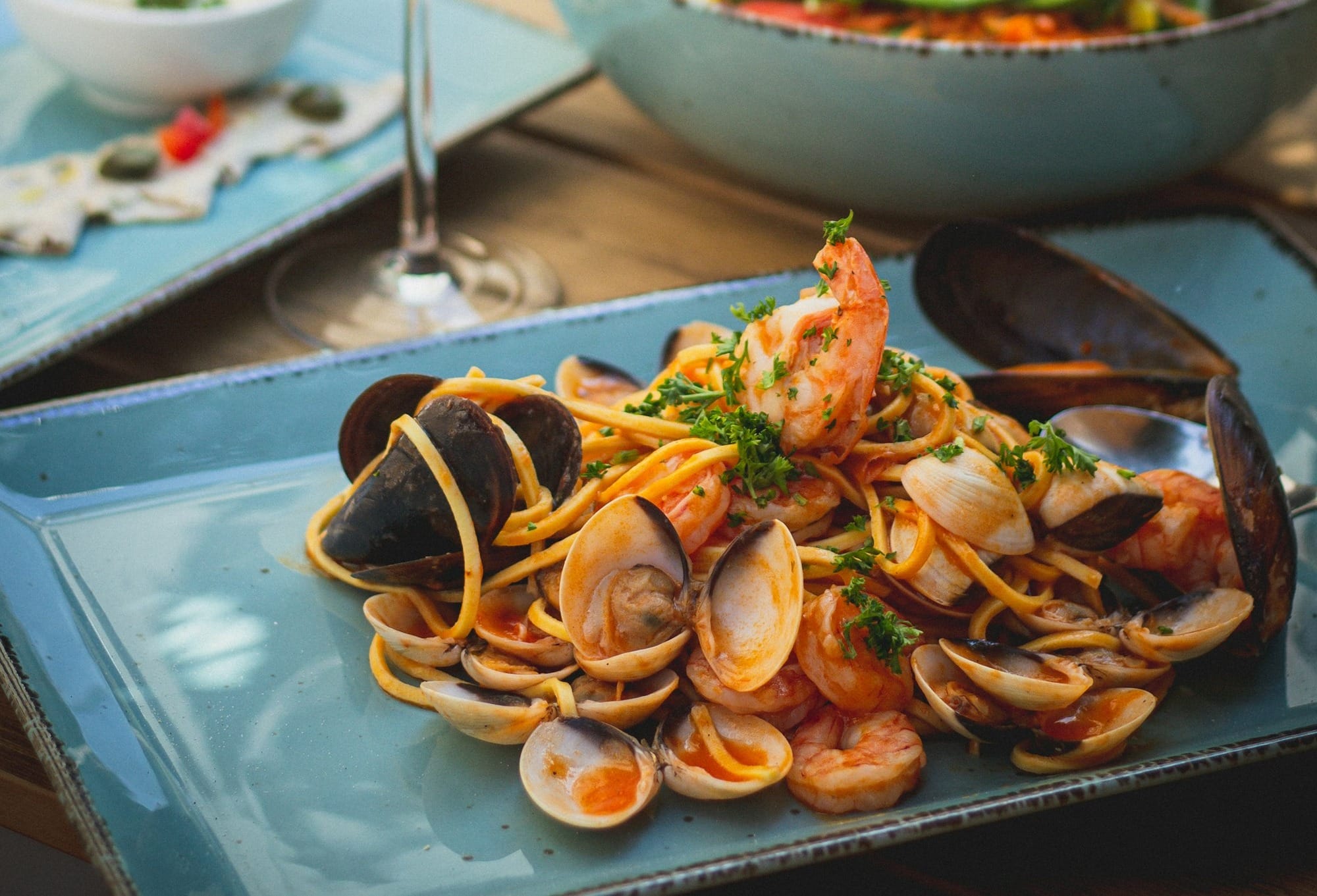 a plate of clams and a glass of wine on a table