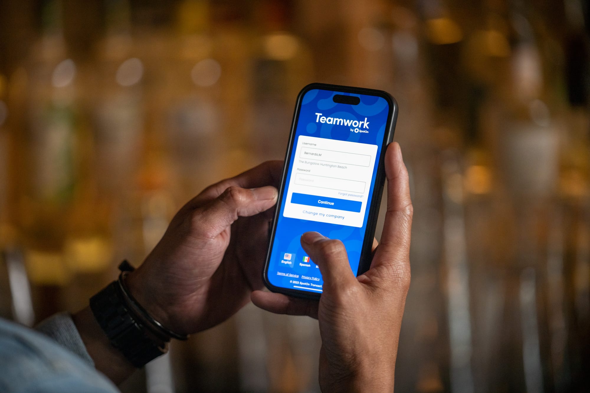 A restaurant employee logs in to the Teamwork by SpotOn app on a smartphone.