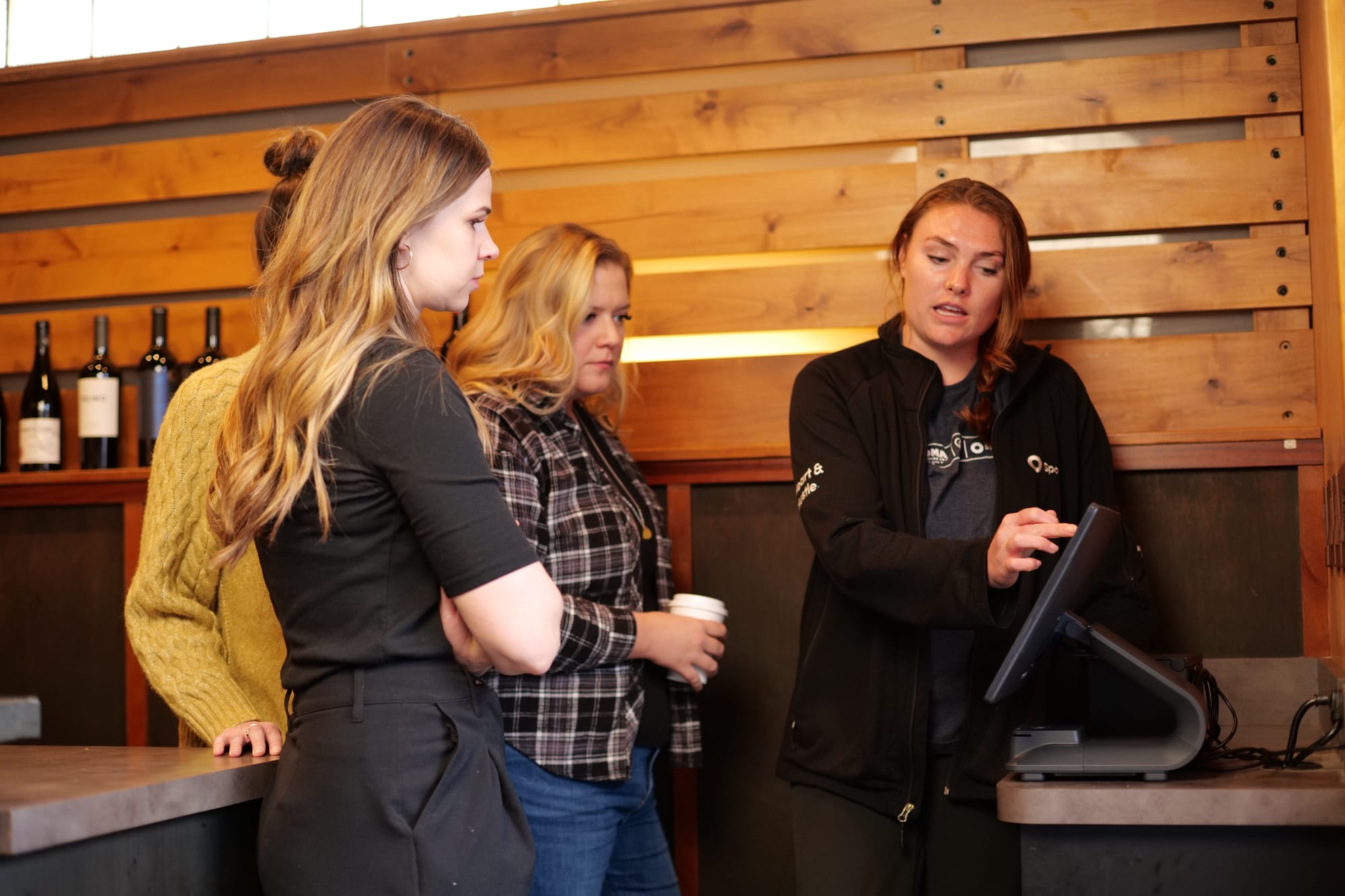 A SpotOn representative demonstrating POS workflows to restaurant staff at a POS station during a training session.
