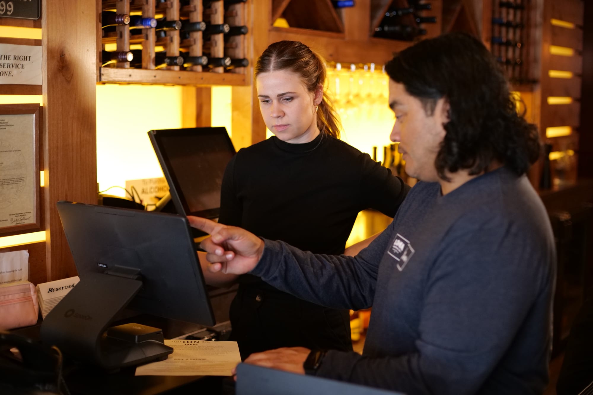 A restaurant staff member receiving one-on-one POS training at a terminal during a post-launch coaching session.