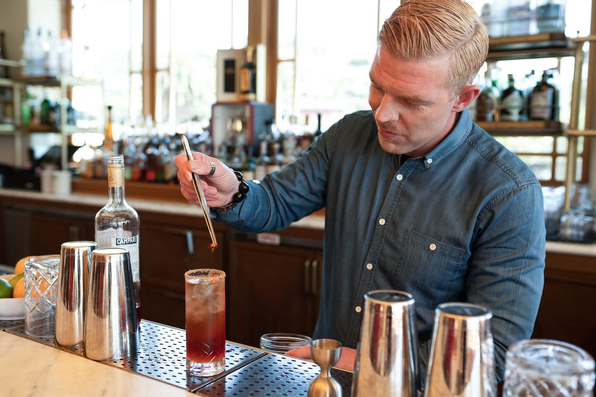 A bartender prepares a drink