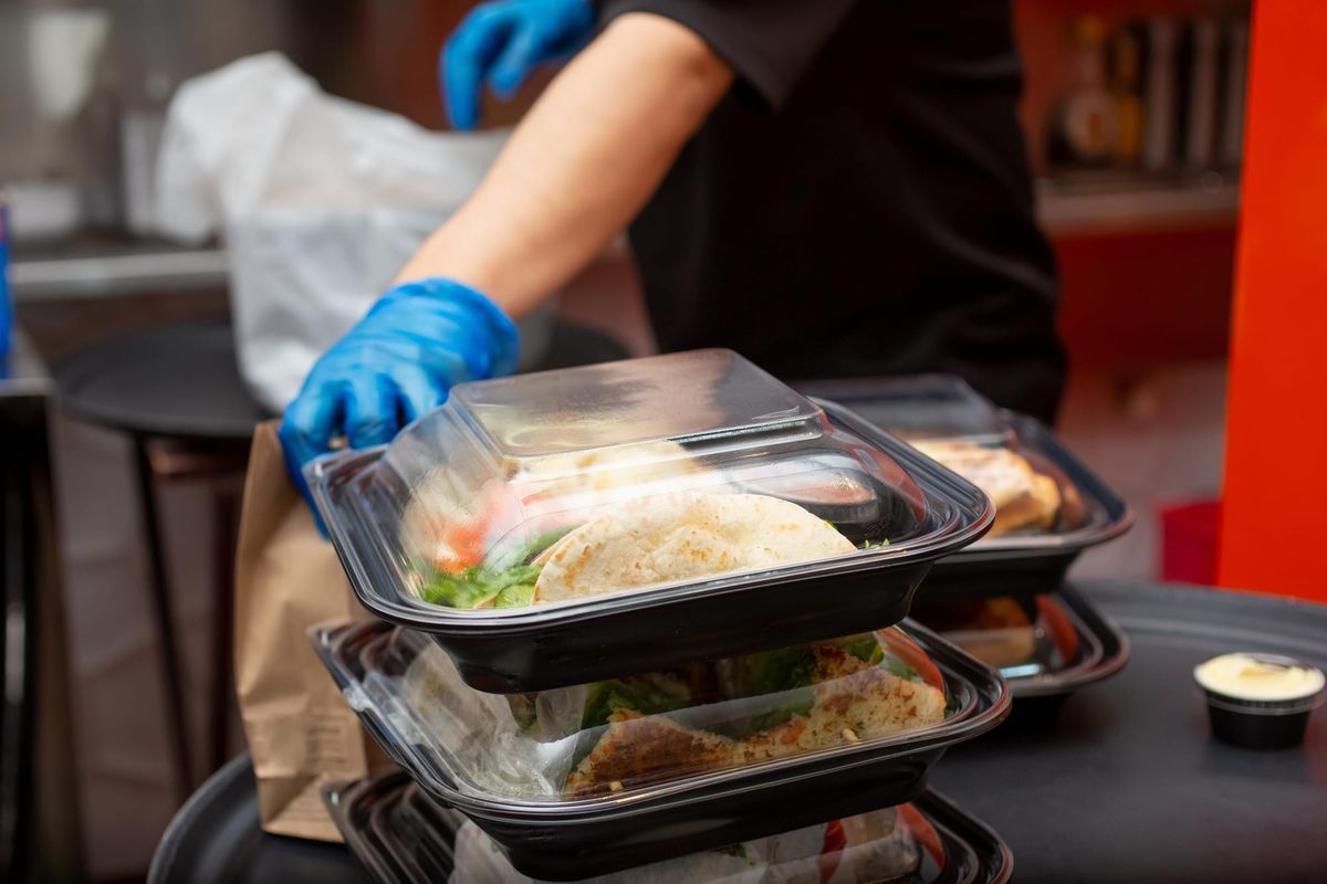 Restaurant employee prepares takeout food for an online order