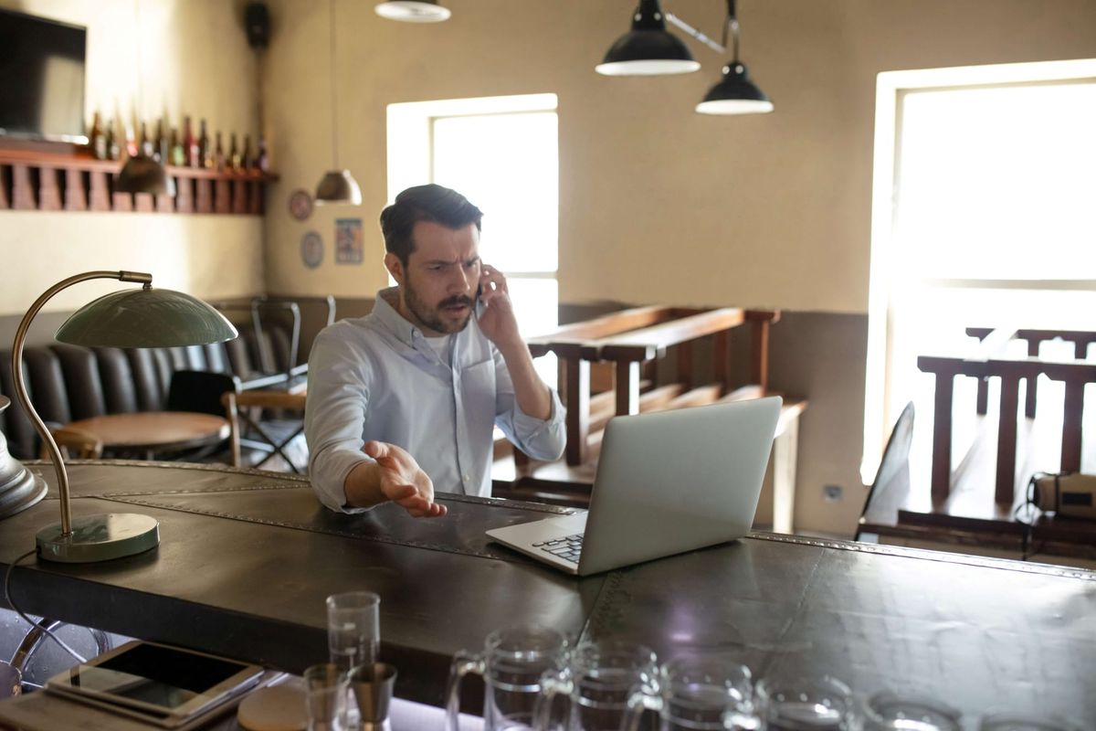 A restaurant owner on the phone inside a closed restaurant