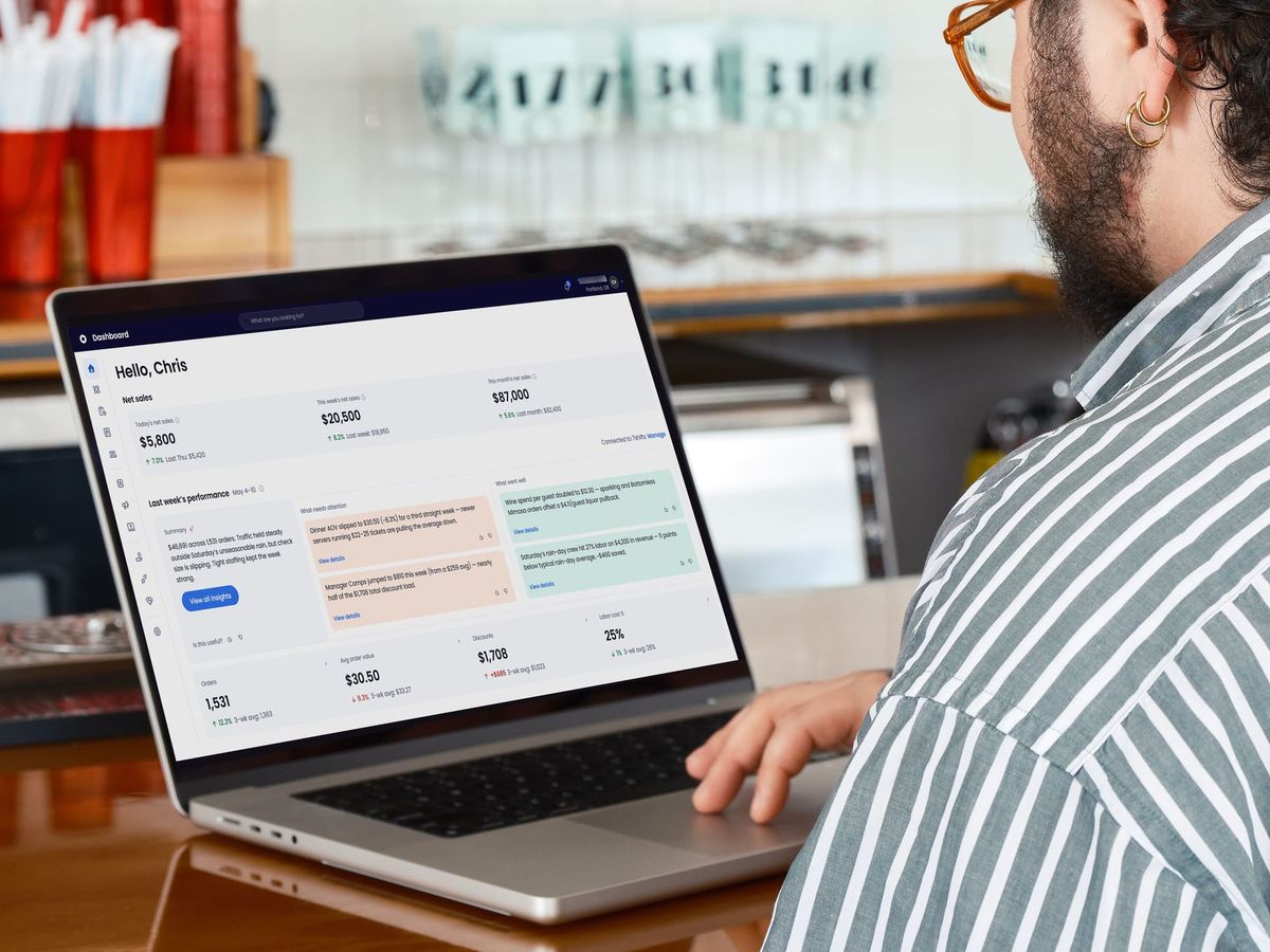 A restaurant operator reviews AI-powered insights about his restaurant on a laptop