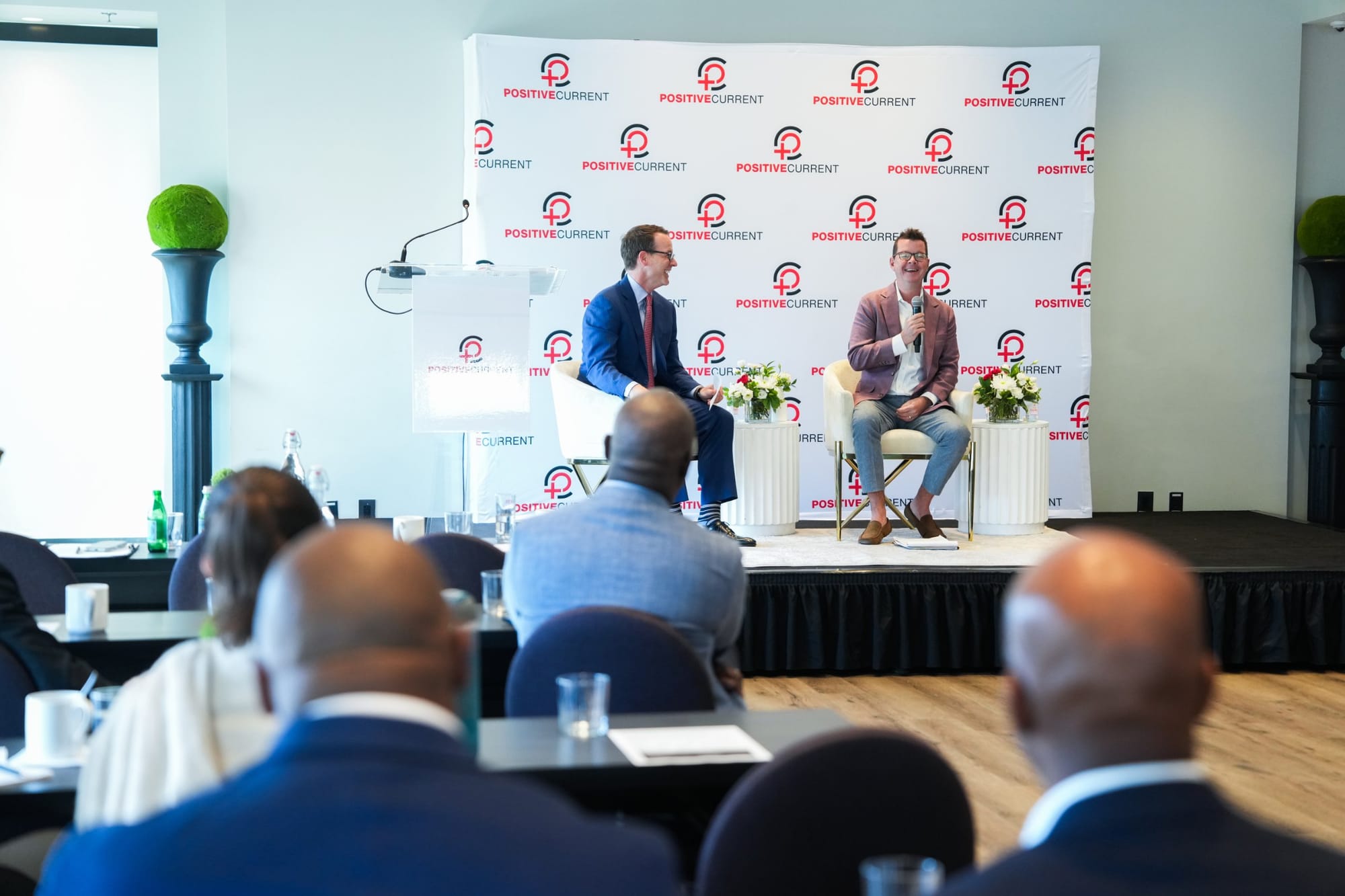 Brody Mullins and Amos Snead in conversation on stage with guests seated in the foreground