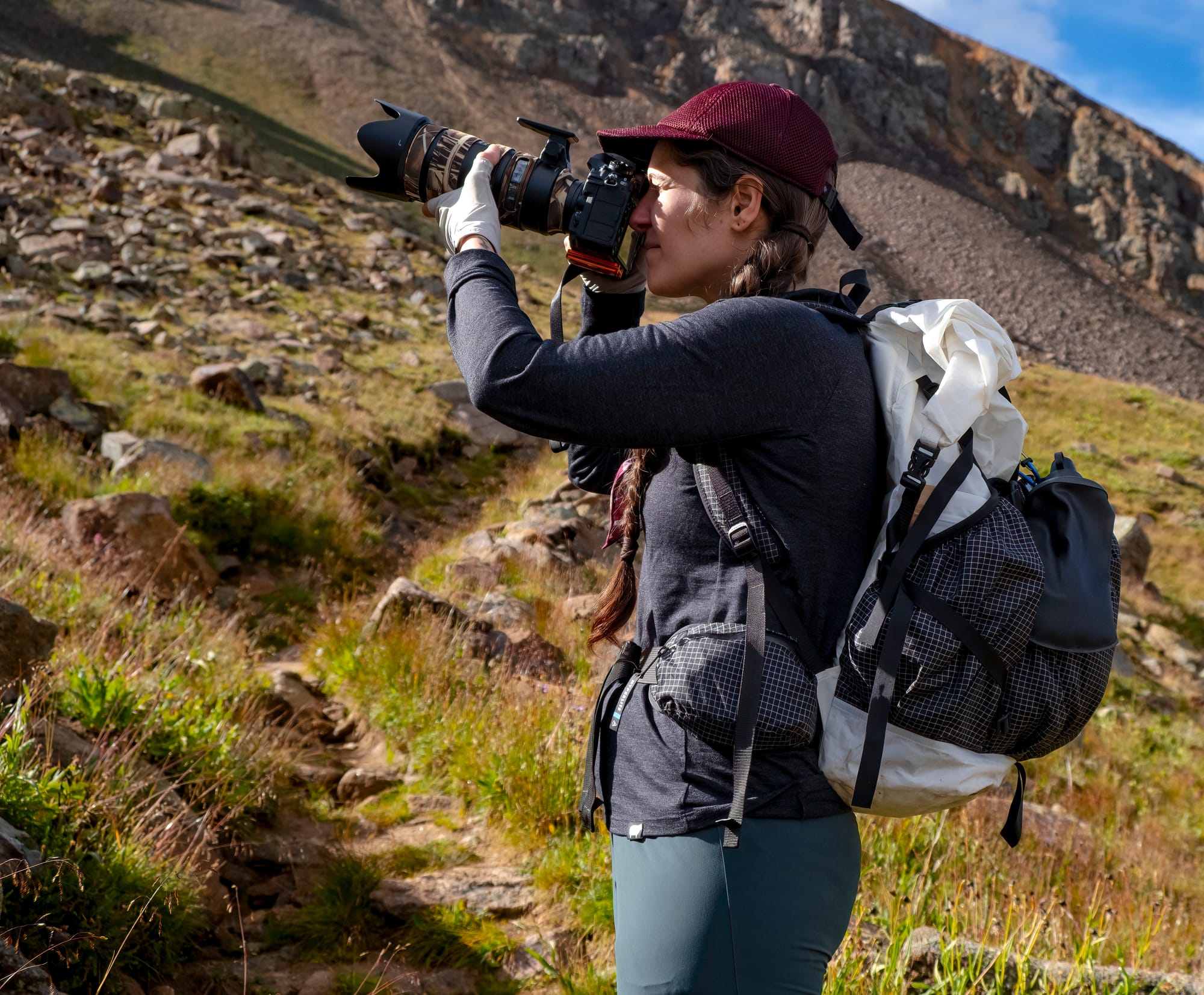 Detail of hip belt and suspension system on Hyperlite Mountain Gear Southwest 70 Backpack. A photographer captures alpine photos while wearing the backpack.