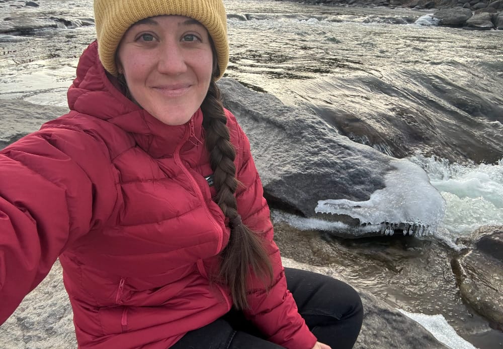 a hiker wearing the tincup ultralight down jacket from katabatic gear for the december gear roundup