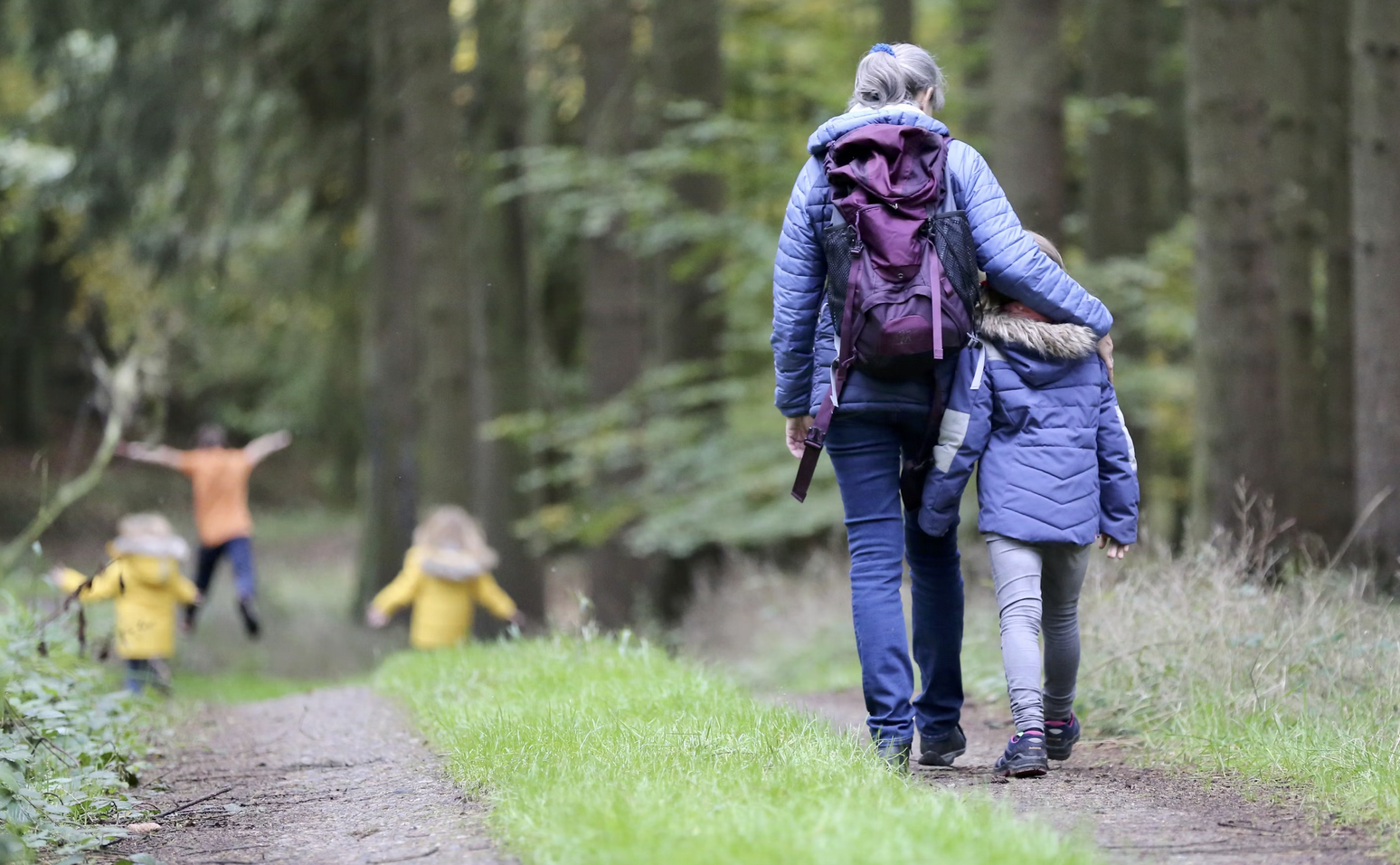 a parent and child bonding together on a nature hike through the woods
