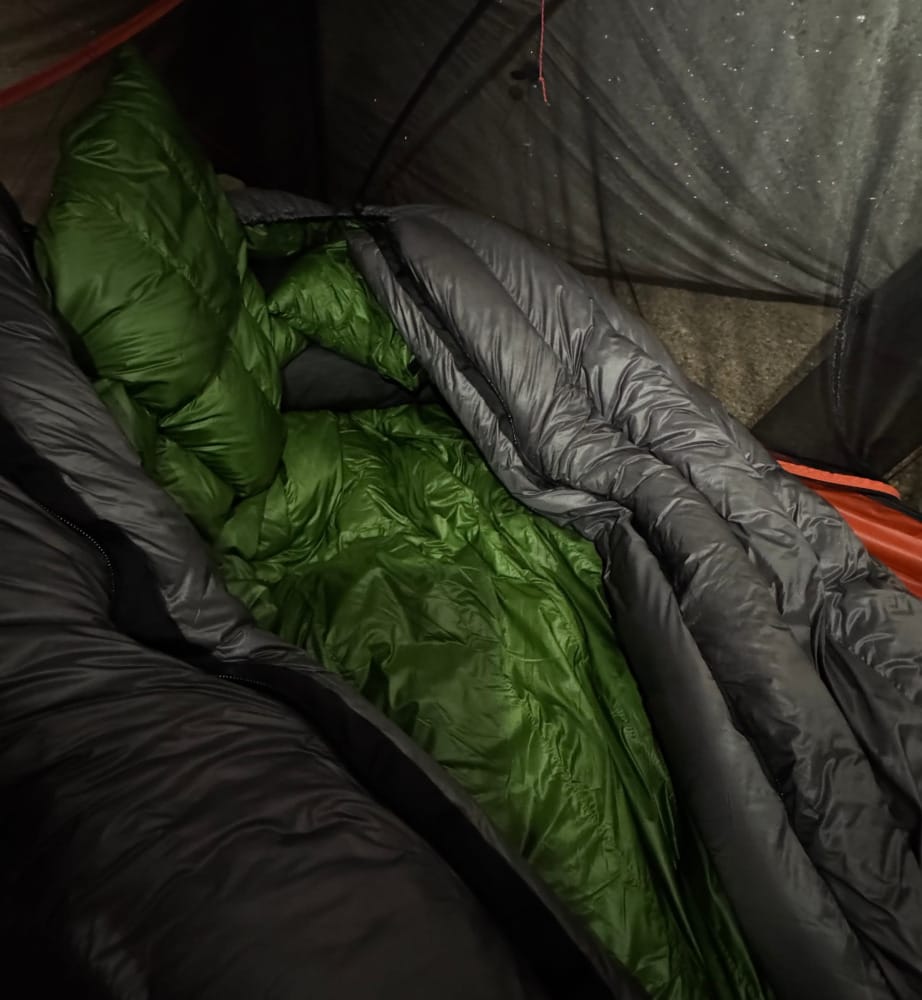 the outdoor vitals summit 0 degree sleeping bag inside a cold tent on a camping trip looking super cozy