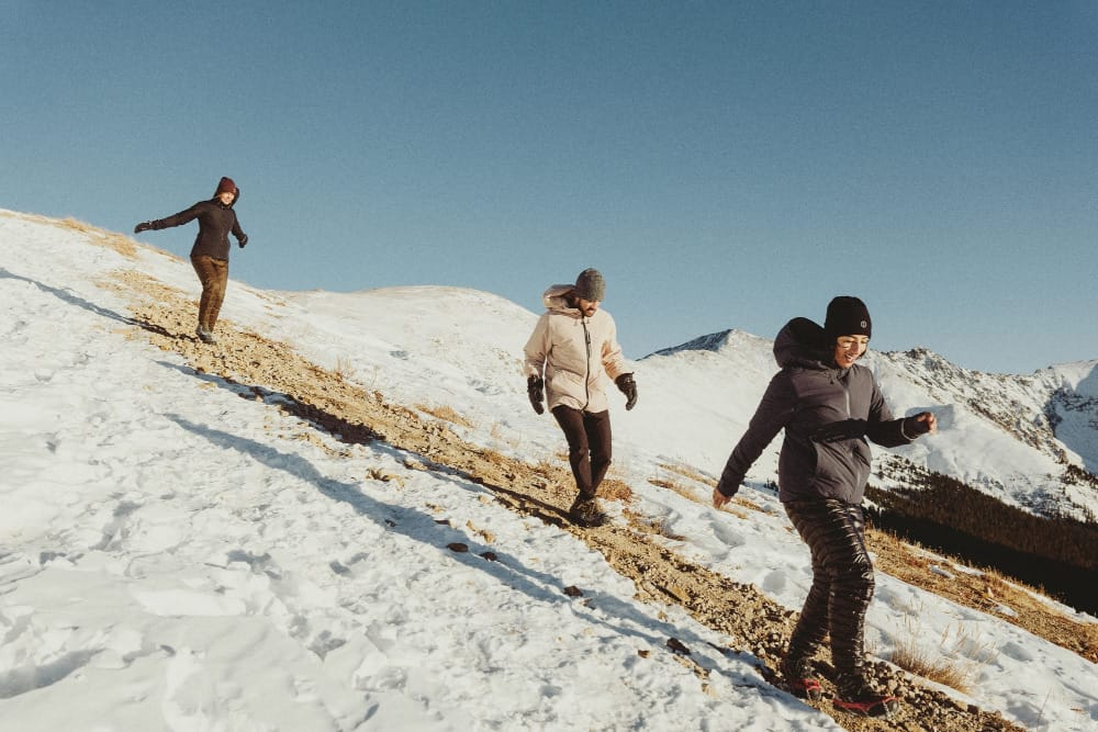 a group of athletes wear pakafill jackets and parkas by paka on the slope of a snowy mountain on a winter day