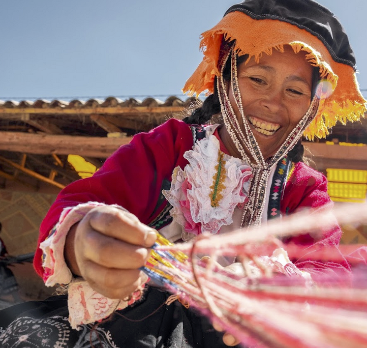a peruvian weaver making a wool garment in the andes