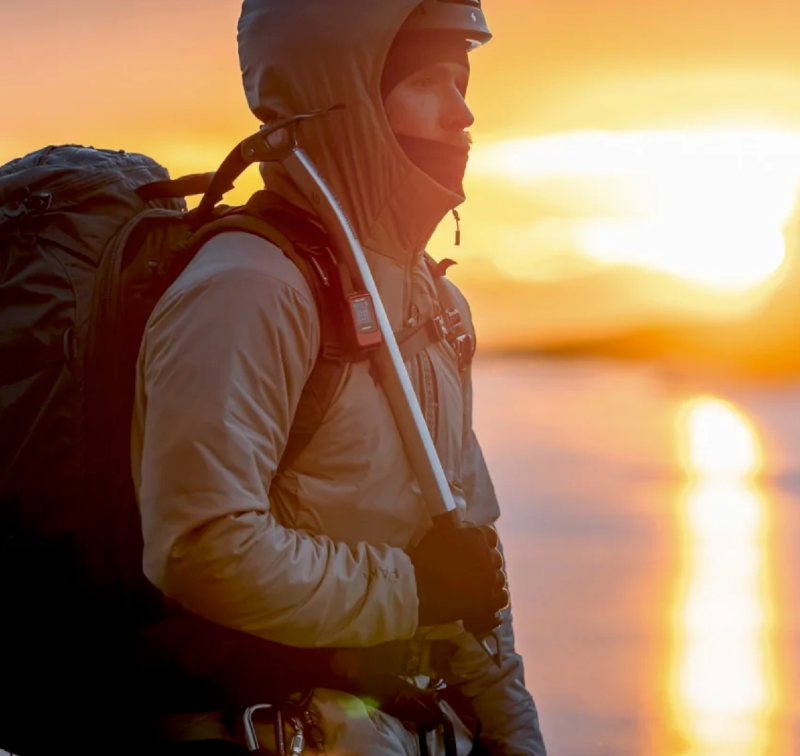 A man wears the apu puffer 2.0 by paka on a sunrise adventure