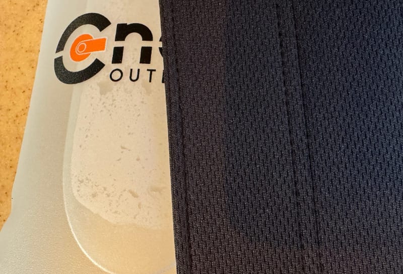 The Hydration Bladder Dryer by BōnDry next to a cnoc outdoor hydration bladder full of water for a hike