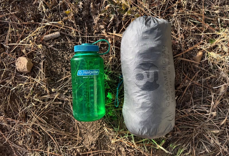 a side by side showing the size of The One Tent By Gossamer Gear next to a nalgene