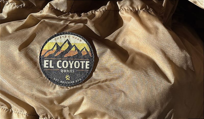 a close up of the AlphaLite 900+ Custom Made Quilt By El Coyote showing some details and logo