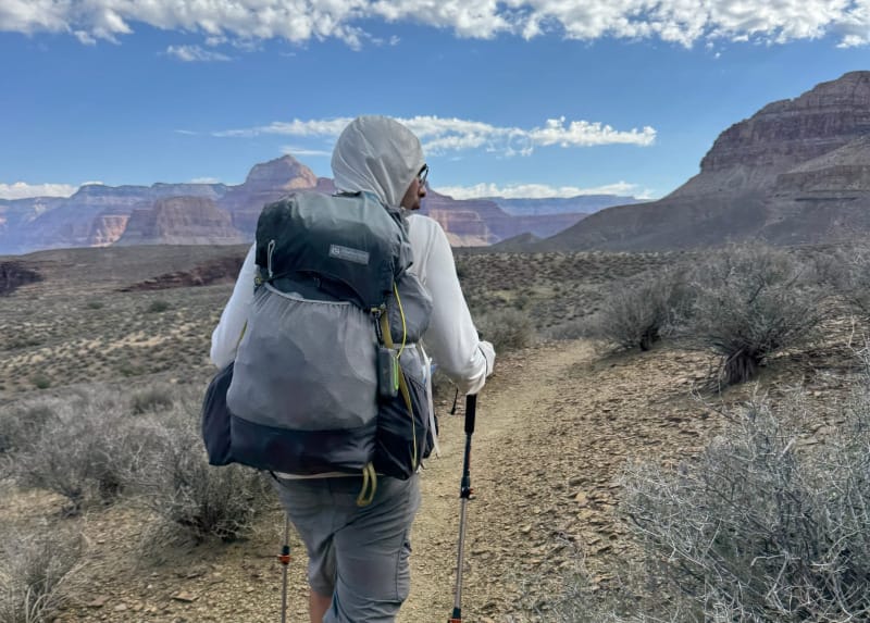 A hiker trekking through the Grand Canyon with a Gossamer Gear backpack, demonstrating lightweight backpacking in a desert landscape.
