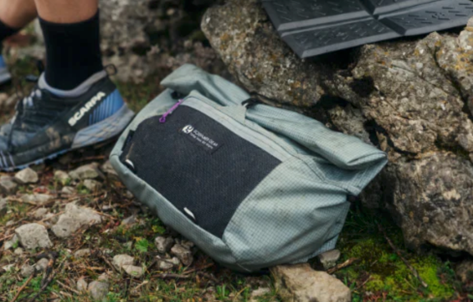 gossamer gear's piku fanny pack on a mossy floor of a spring 2025 hike in the woods